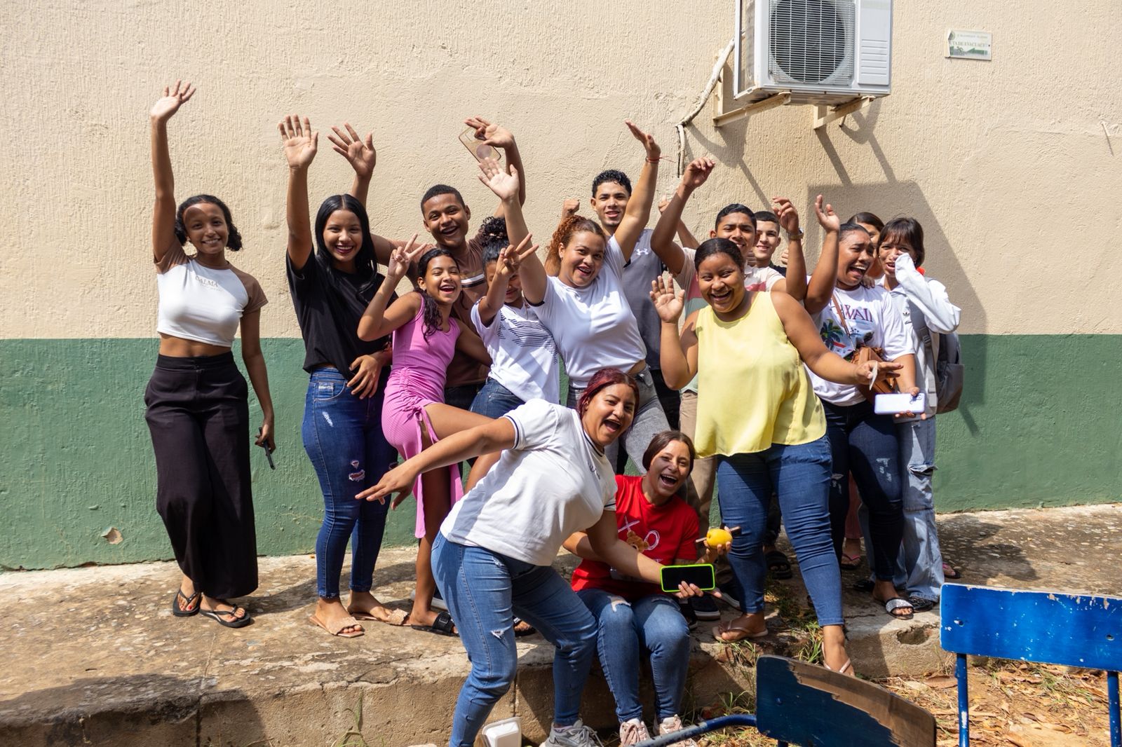 grupo de jóvenes en paz levantando los brazos y sonriendo