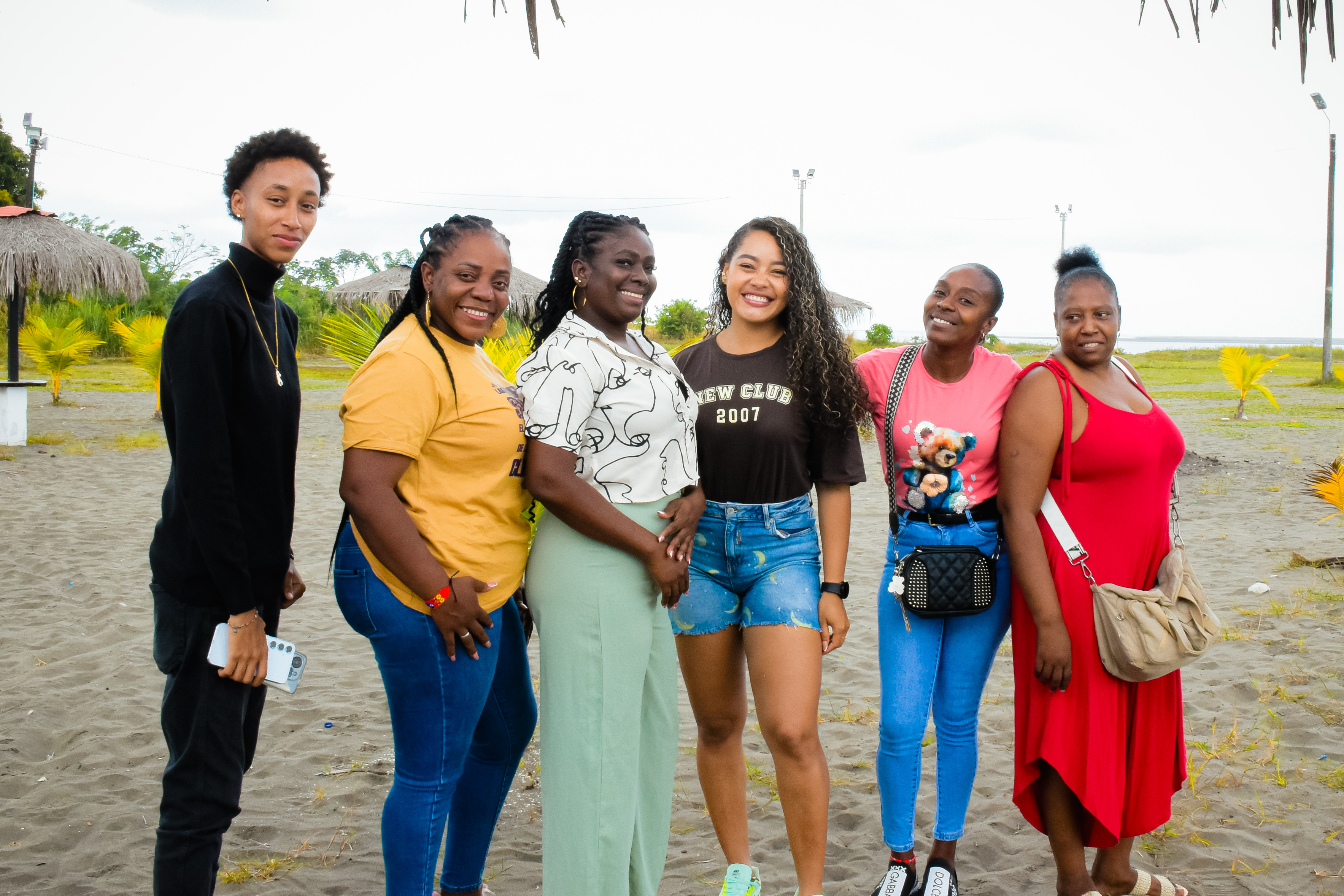 Personas afro, negras, palequeras y raizales posan de pie sobre la arena en una playa de Tumaco. Al fondo se alcanza a ver el mar pacífico