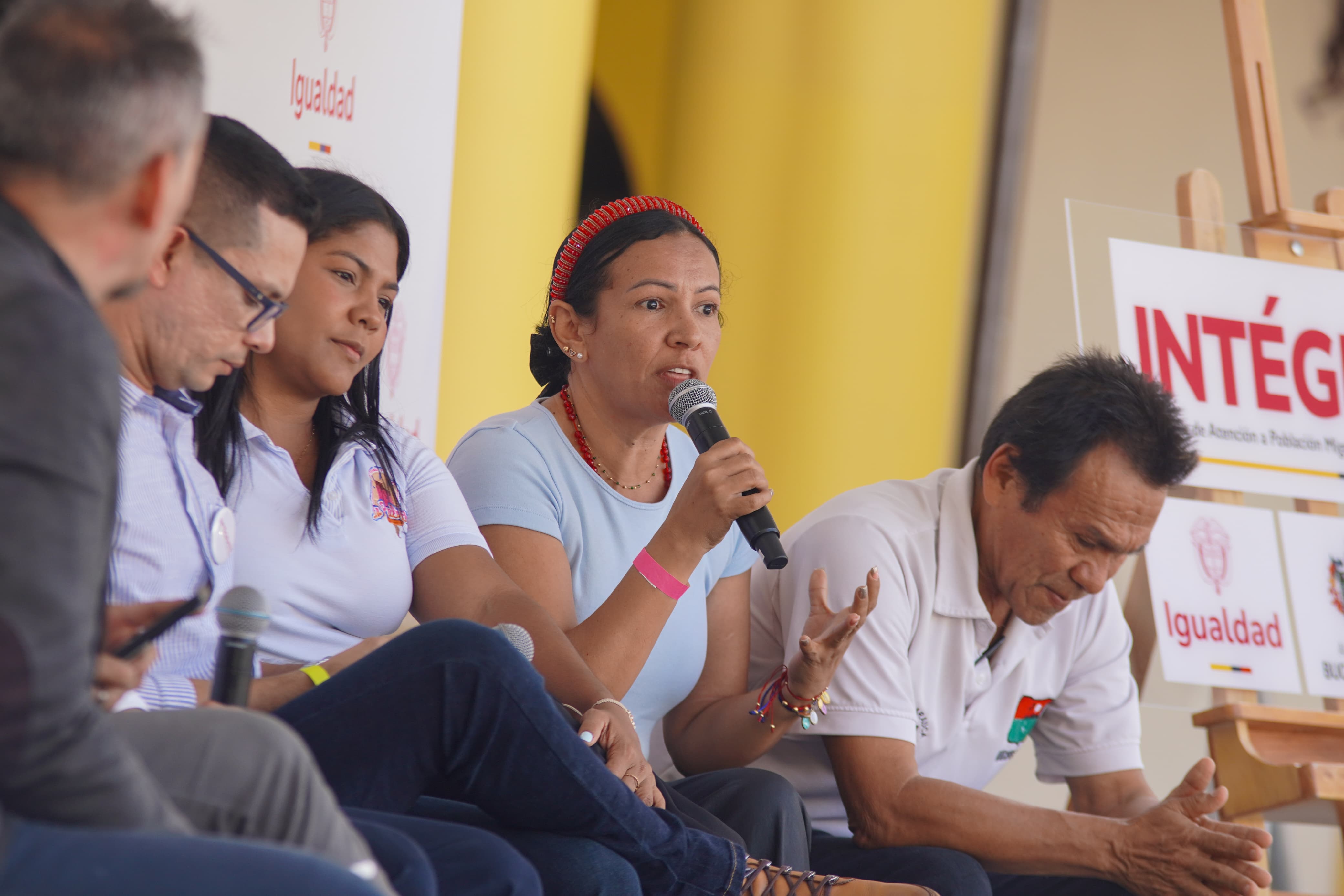 Inmigrantes venezolanos hablan en tarima durante el evento de presentación en Bucaramanga de los centros Intágrate