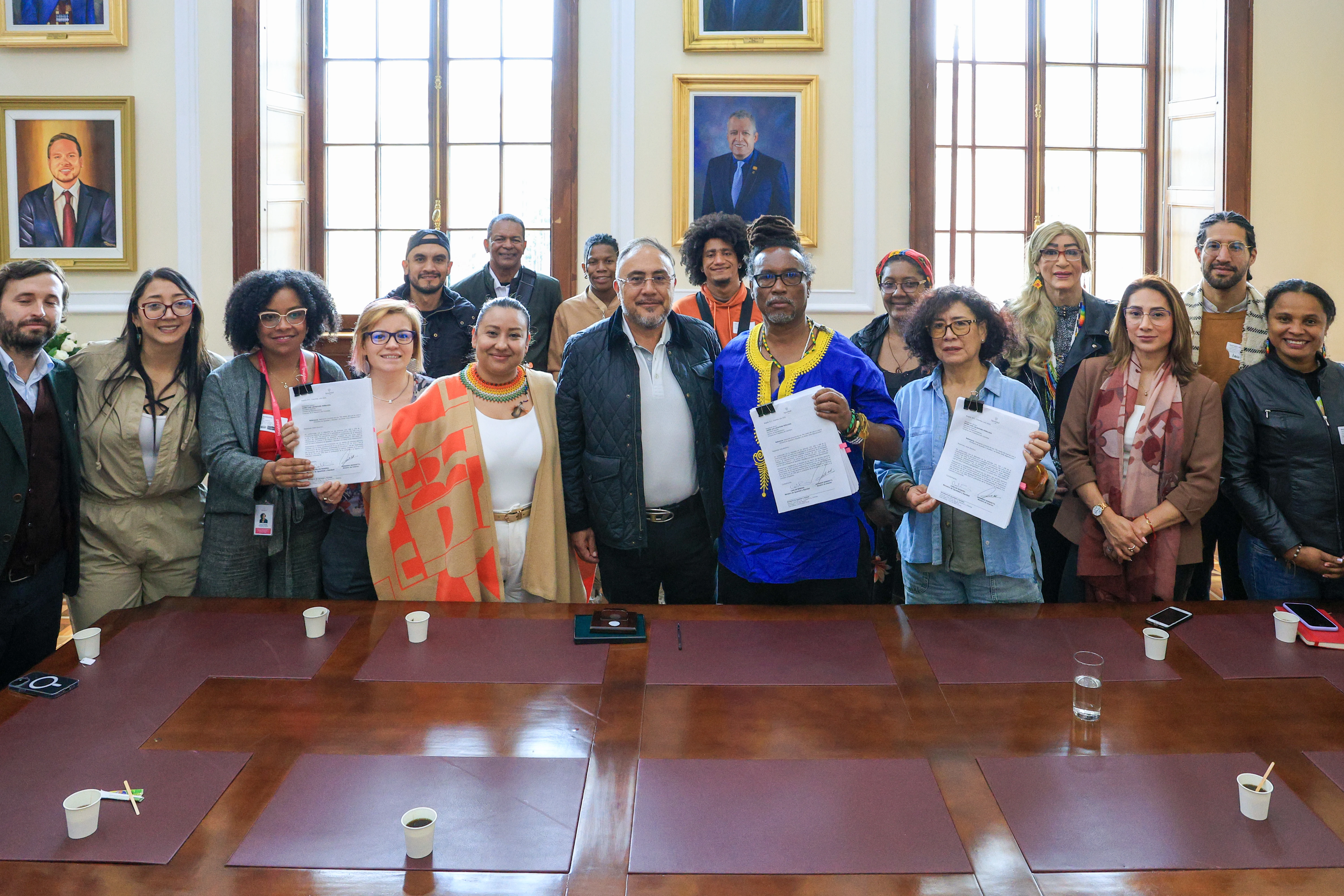 El ministro Carlos Rosero en una sala del Capitolio Nacional acompañado de su equipo de trabajo posa con el proyecto de ley en su mano izquierda