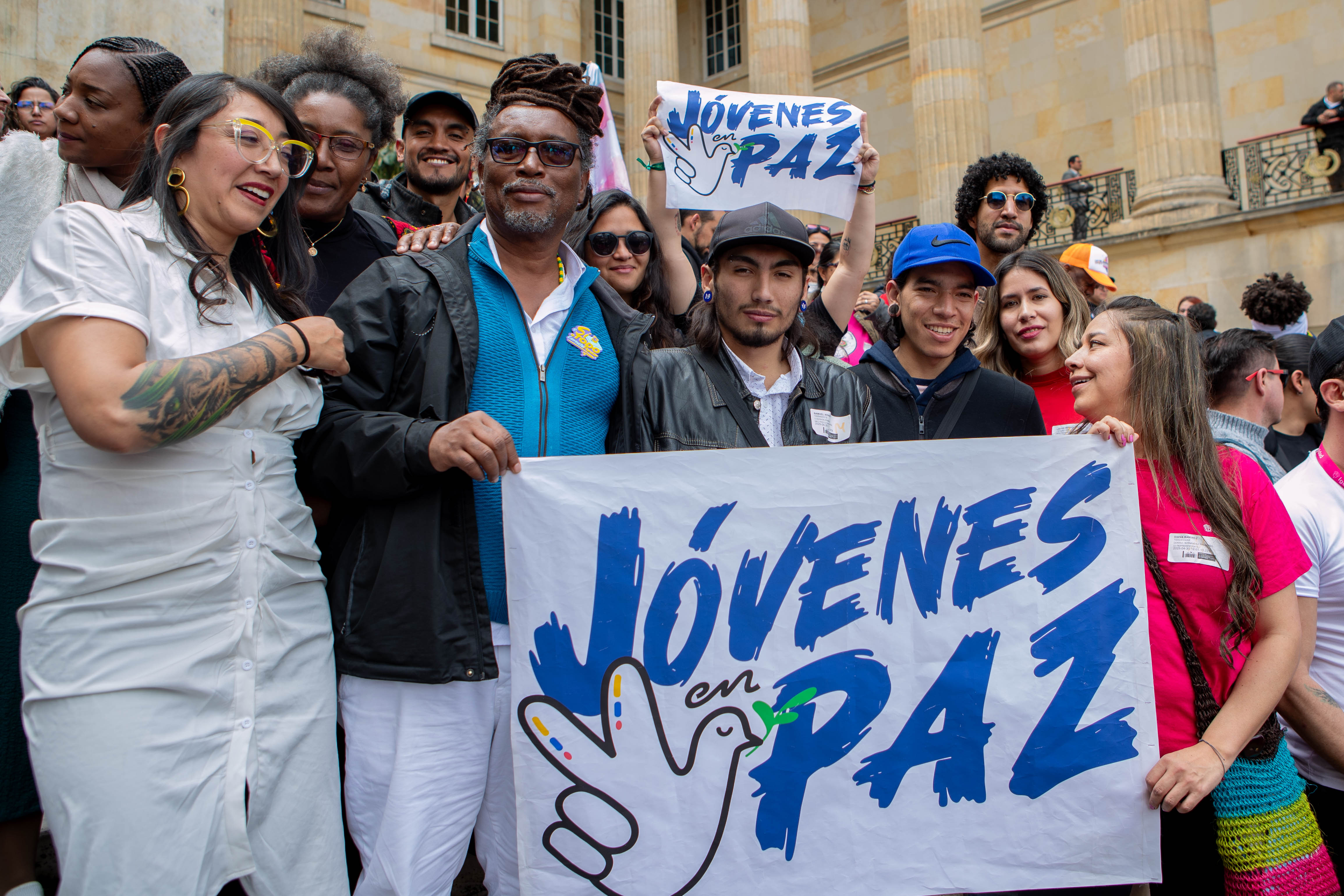 Ministro Carlos Rosero con jóvenes que sostienen pancarta del programa Jóvenes en Paz