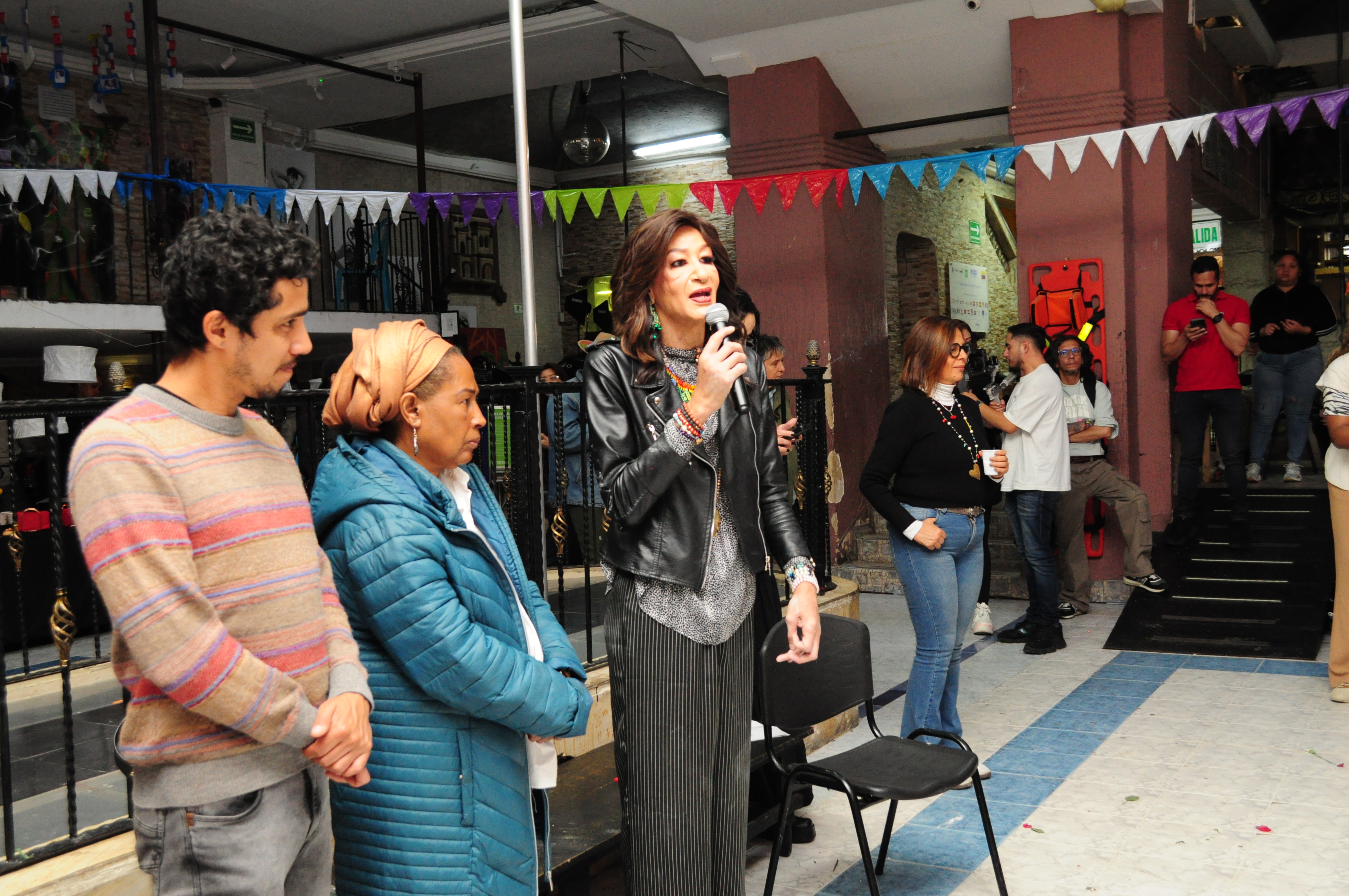 Foto con panel de la Feria de Inclusión Socioeconómica Cultural: Migración y Cuidado entre Mujeres y Personas Trans en Contextos de Actividades Sexuales Pagas, Calle y Espacio Público
