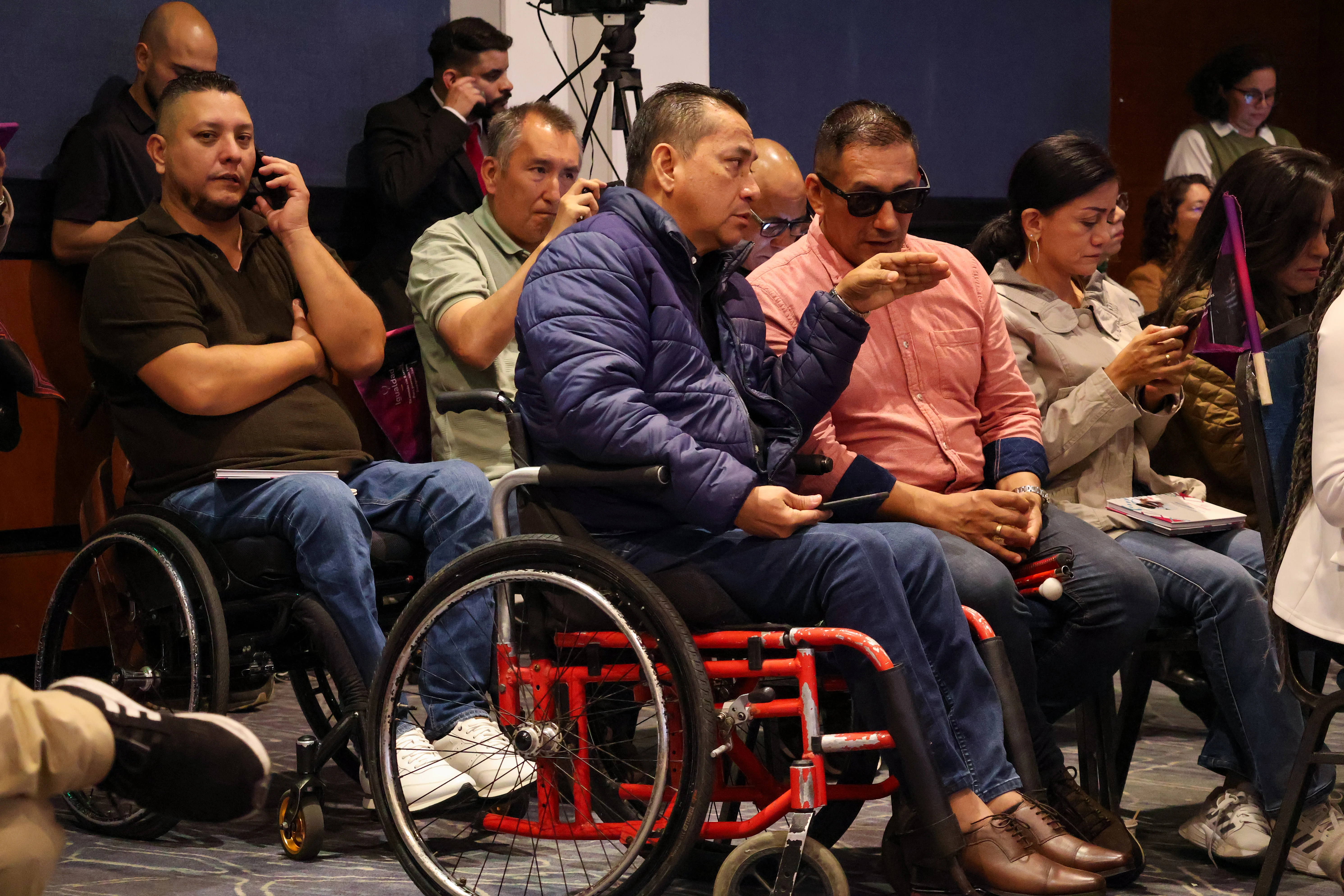 Personas con diacapacidad fisica en sillas de ruedas y otras con discapacidad visual asisten al encuentro en Bogota para conmemorar el dia internacional de las personas con discapacidad