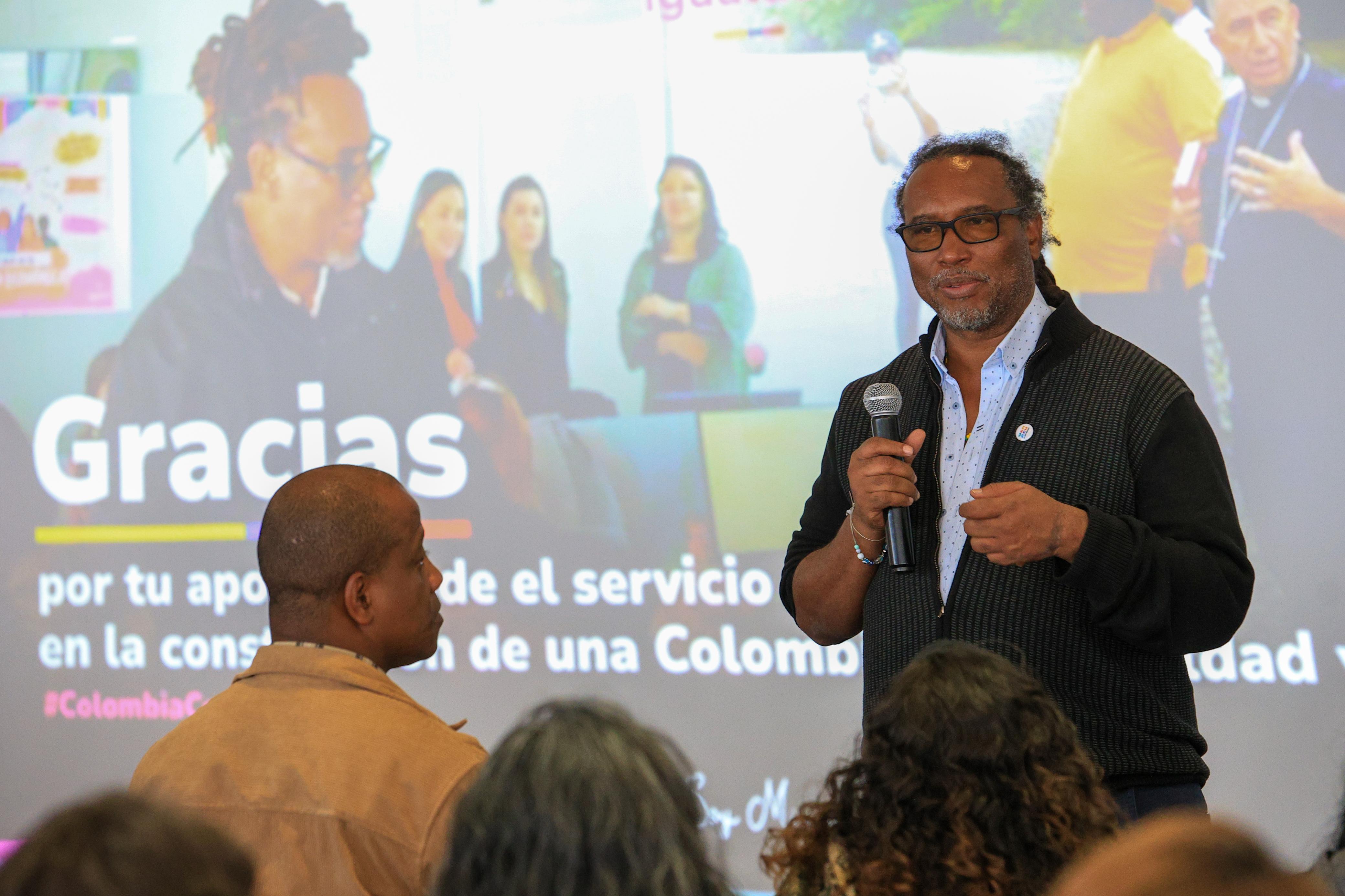 Ministro Rosero con micrófono en mano se dirige a funcionarios y funcionarias durante la conmemoración del Día del Servidor Público