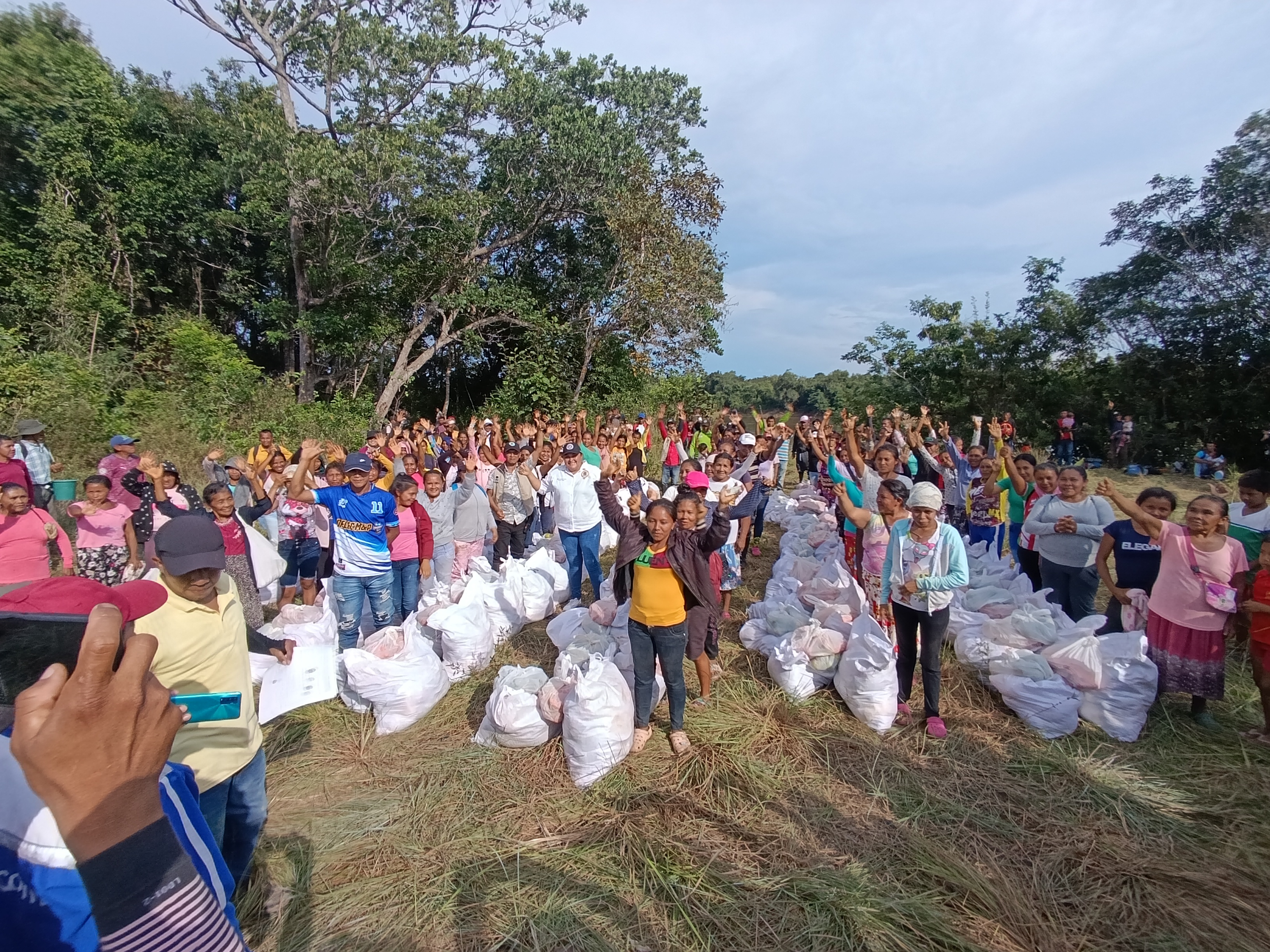 Familias indígenas en zona rural de Cumaribo reciben provisiones alimentarias. En la foto decdenas de personas formadas en varias filas con sus costales llenos de alimentos en medio de la arboleda