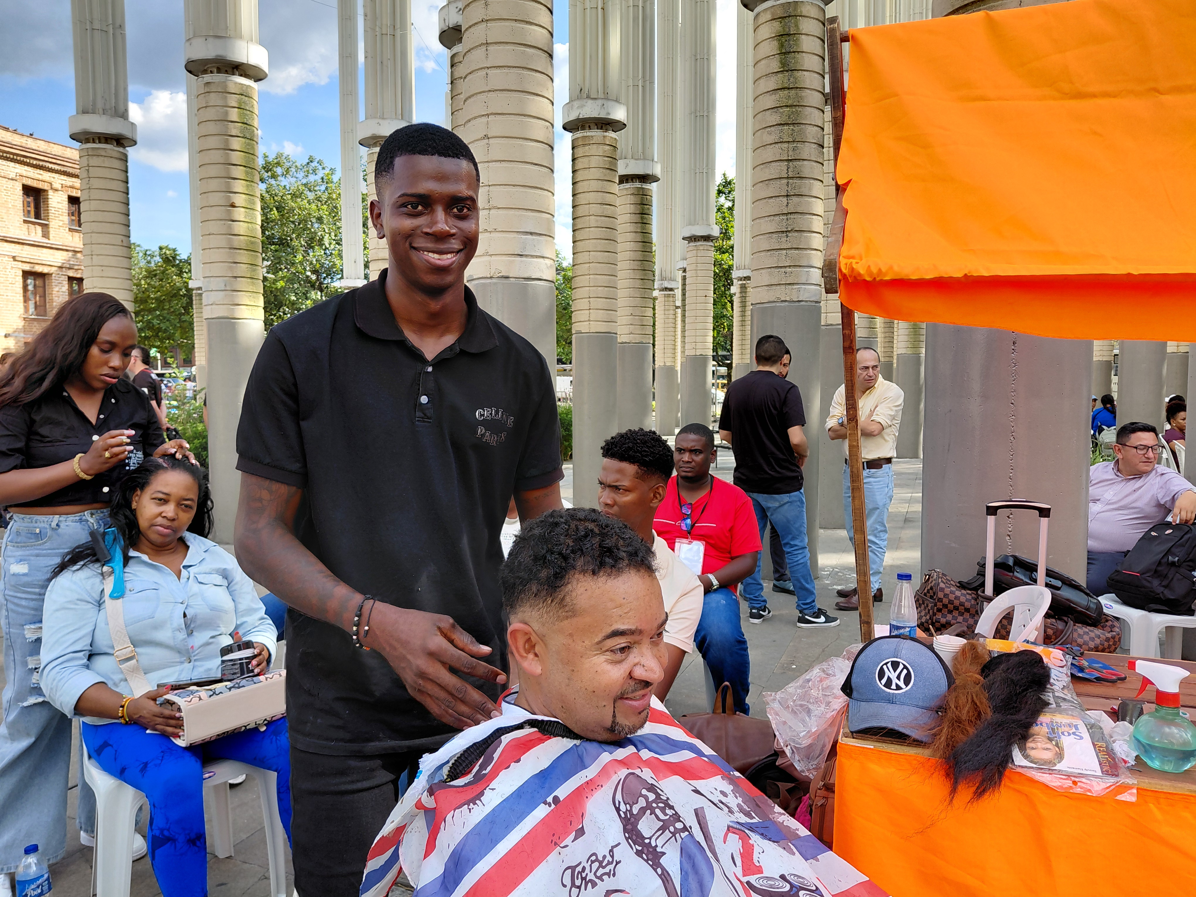 Una persona vinuclada a Jóvene en Paz, muestra su emprendiemimnto de peluquería en medio de la plza de las luces de Medellín