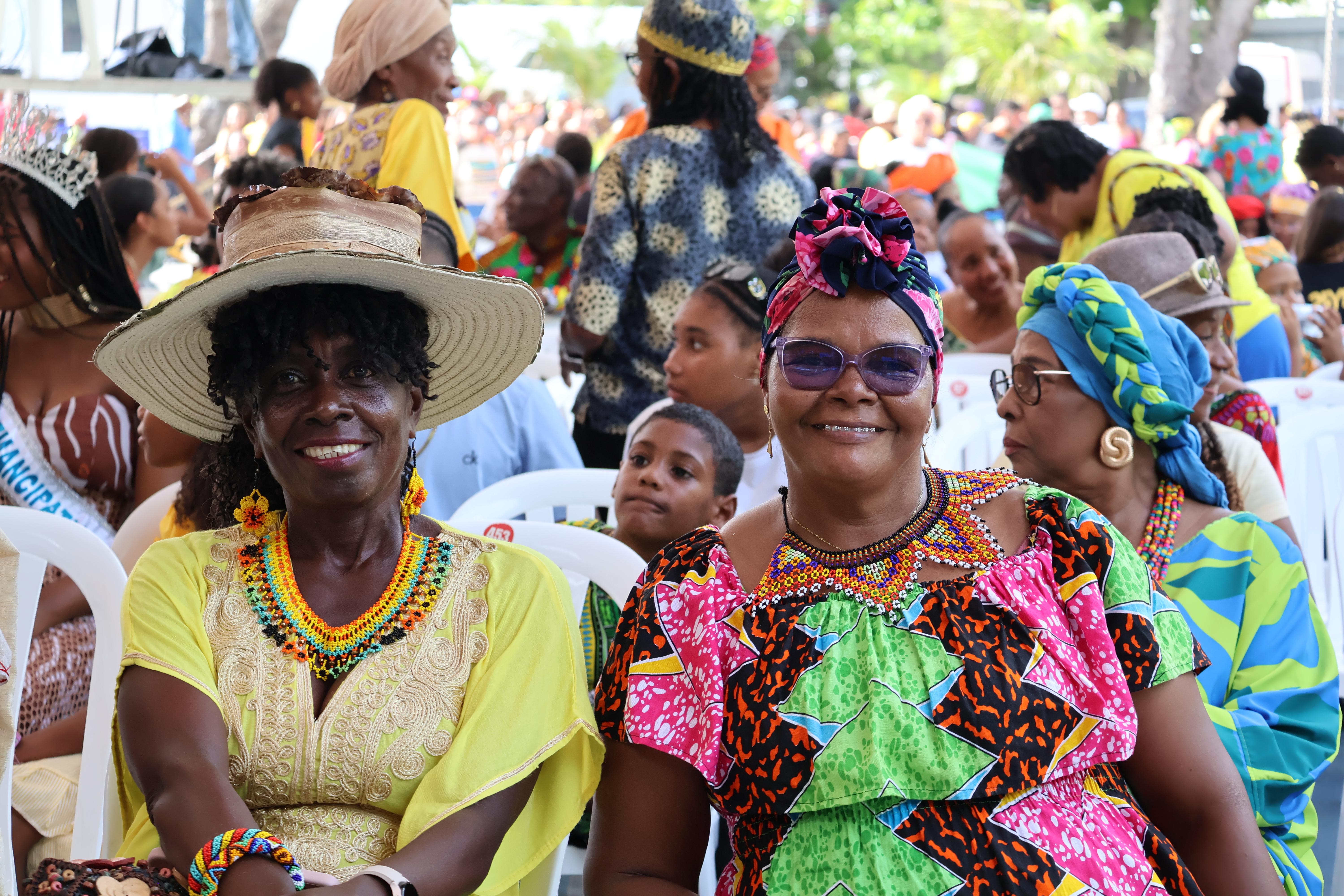 Mujeres raizales con sus hijos e hijas sentadas durante evento al aire libre en San Andrés Islas