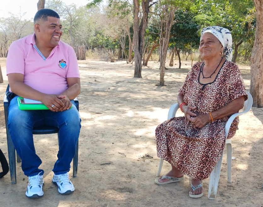 Mujer indígena sentada afuera de su casa atiende entrevista de los técnicos de FUPAD