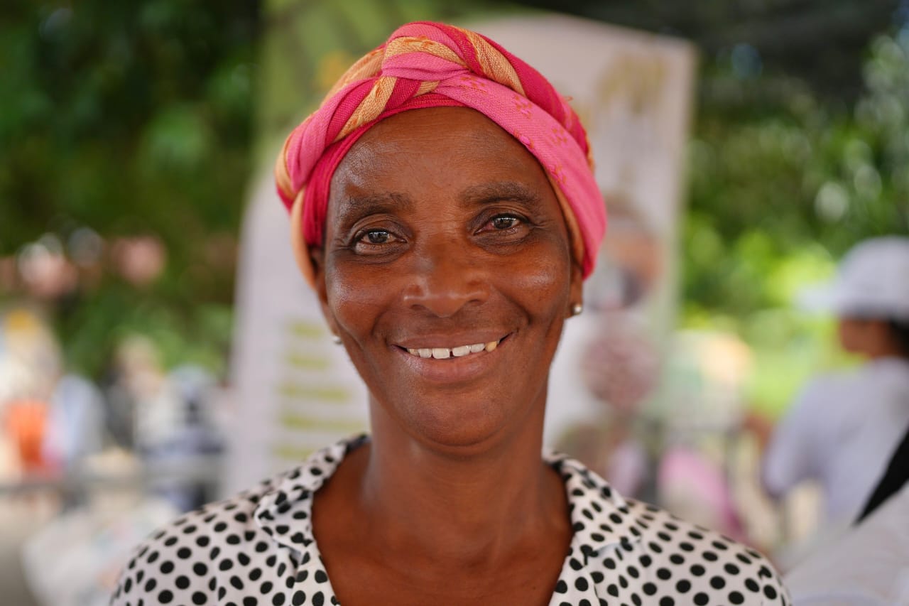 Primer plano mujer campesina afro con blusa blanca de pepas negras y turbante de colores