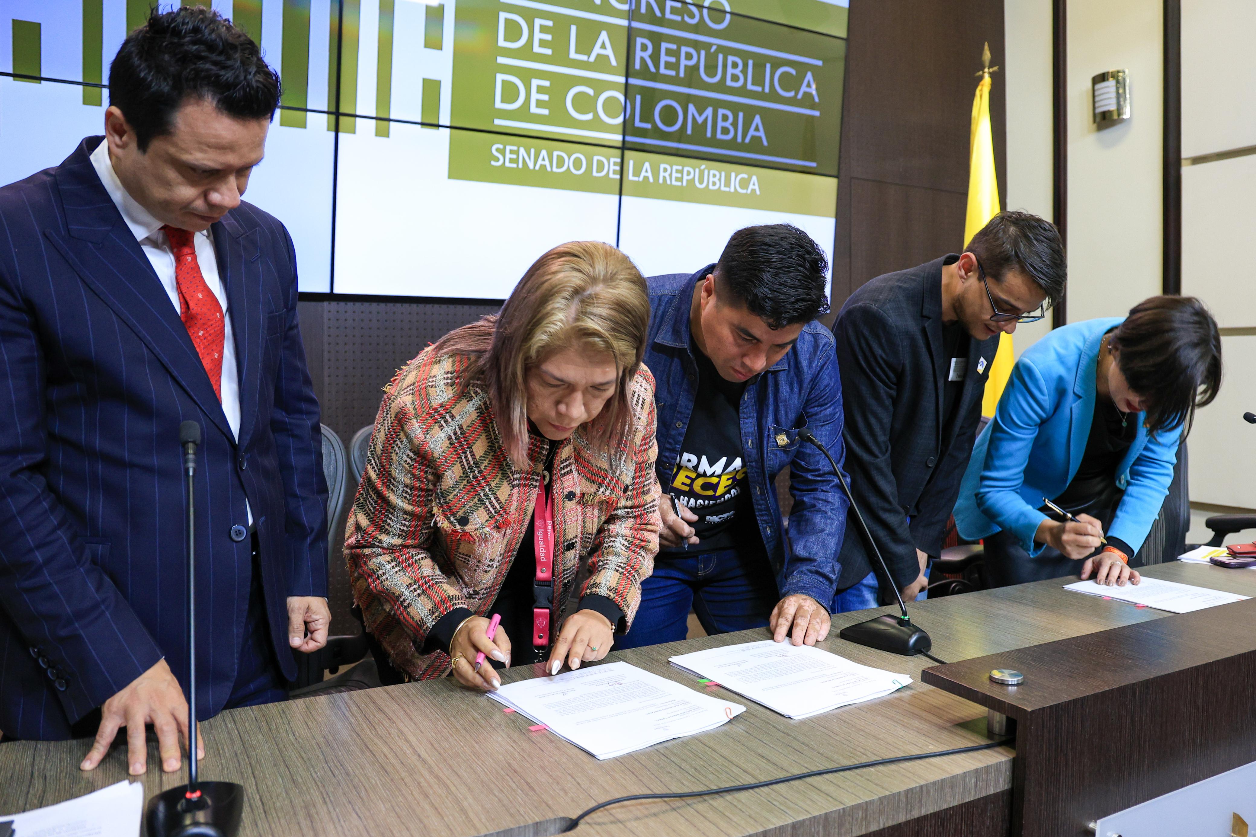 Imagen plano medio de le Secretaria General Lida Magally Rodríguez firmando sobre una mesa la radicación del proyecto de ley del derecho humano a la alimentación adecuada