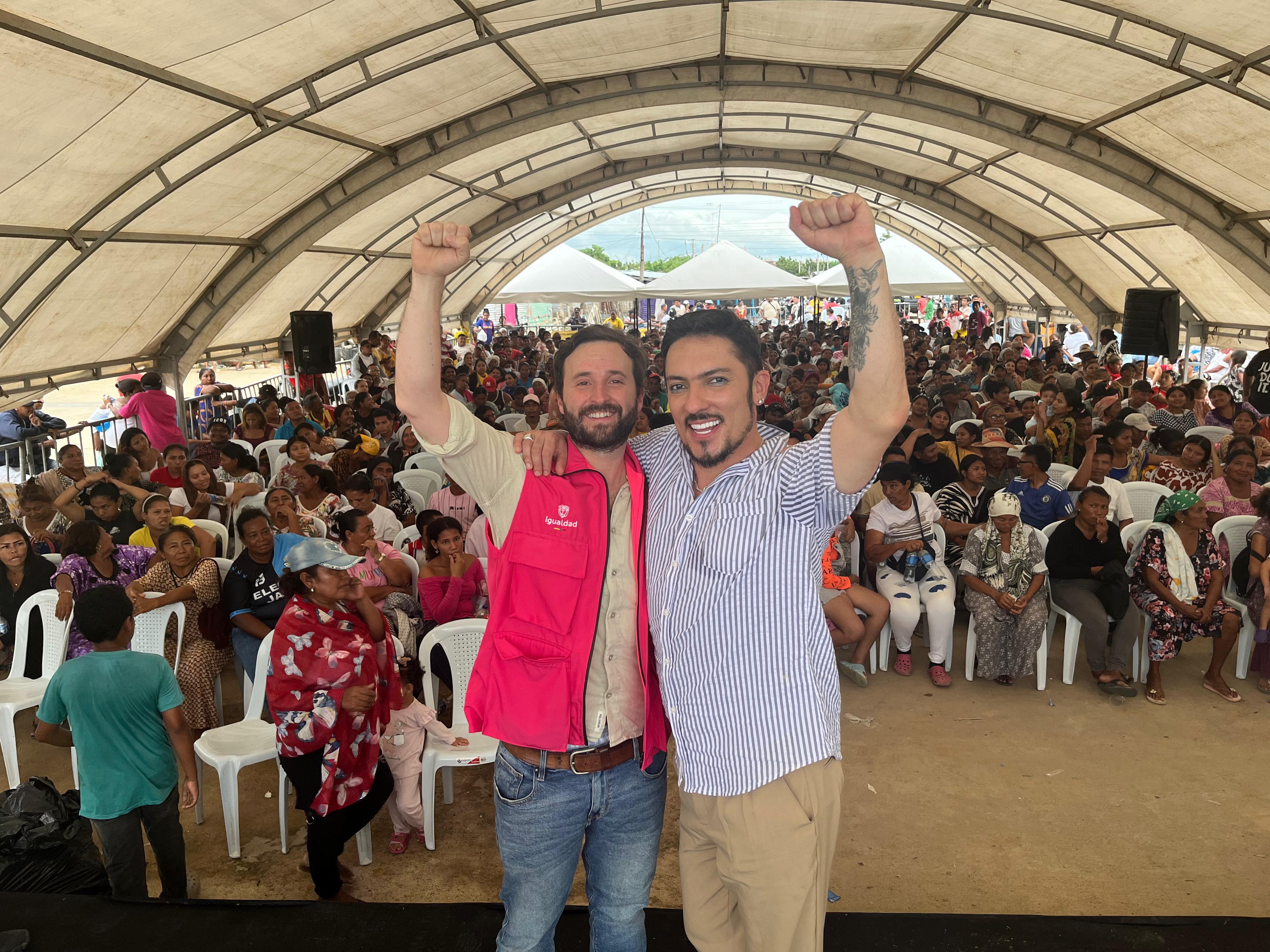 El ministro Florián Silva con el viceministro Pablo Pardo abrazados levantando sus brazos en la tarima, de fondo el público asistente bajo una gran carpa